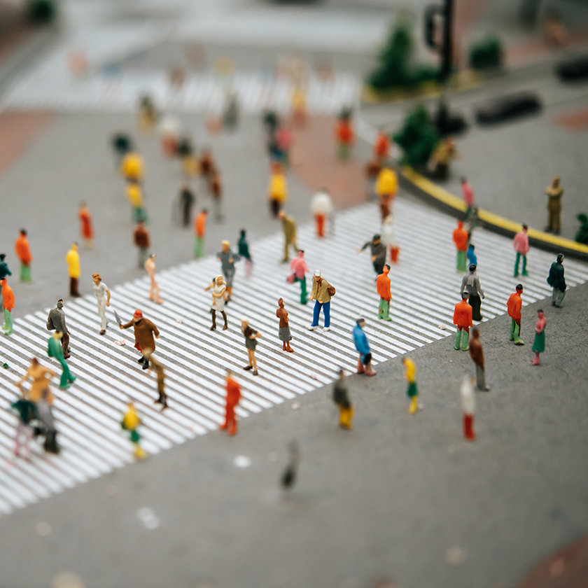A crowd of people crossing a busy road