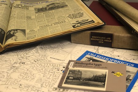 An array of old newspapers spread across a desk