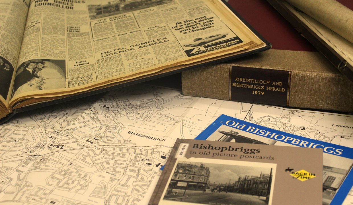 An array of old newspapers spread across a desk