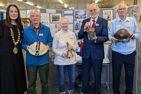 Depute Provost Colette McDiarmid in Milngavie Library standing with four other peoples holding artefacts