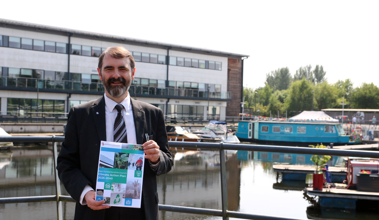 Councillor Low is pictured at Southbank Marina holding a copy of the Climate Action Plan.