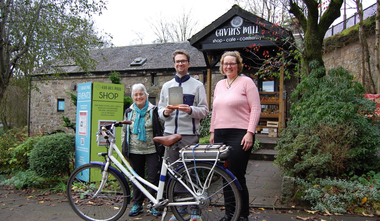 Three people stand outside the Gavin’s Mill premises in Milngavie with a bicycle - (from left) Dr Sue Milne, Cllr Paul Ferretti and Uta Engelbrecht, who is part of the Gavin’s Mill team and uses the app with her family.