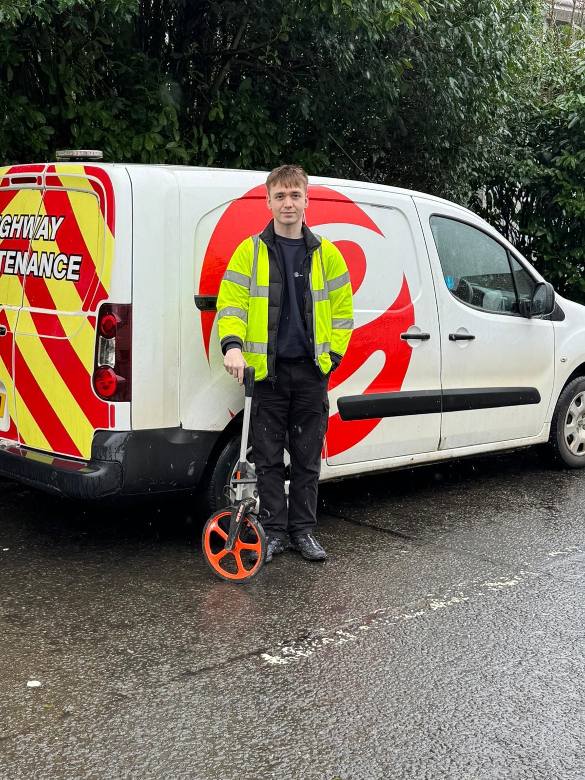 young man in hi vis jacket standing in front of an East Dunbartonshire Council van. 