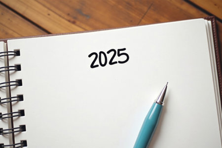 Notepad that has '2025' written and a pen sitting across the page.
