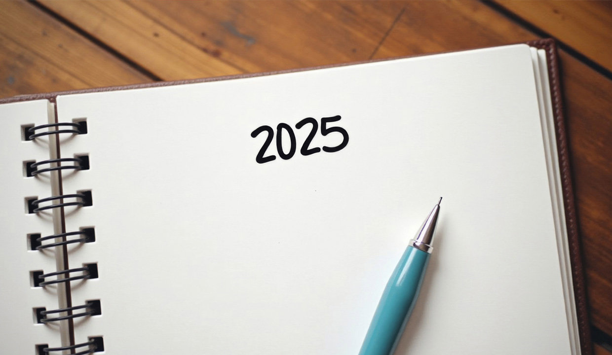 Notepad that has '2025' written and a pen sitting across the page.