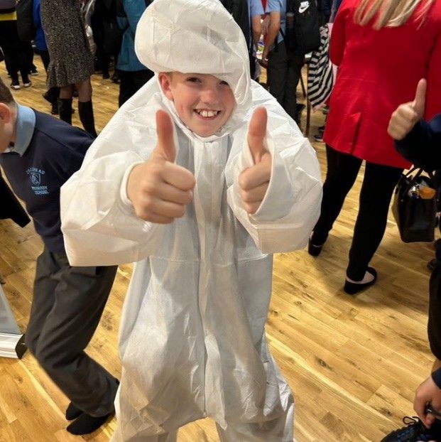 child in  hazmat suit giving thumbs up