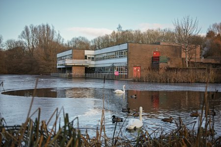 Milngavie library with a swans and ducks on the water