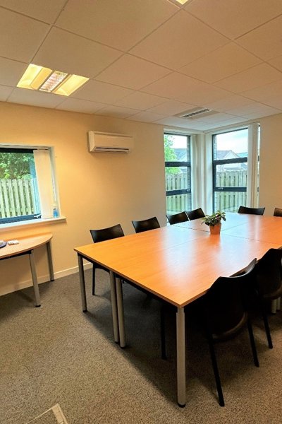 Meeting room with table and chairs and a small table at the window