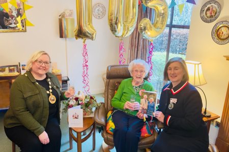 Provost Gillian Renwick sitting with Agnes Jenkins.  Gold 105 birthday balloons behind them