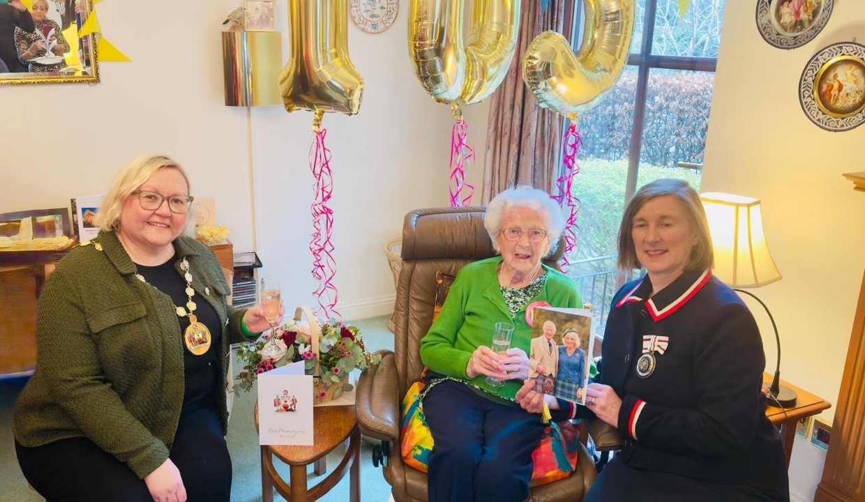 Provost Gillian Renwick sitting with Agnes Jenkins.  Gold 105 birthday balloons behind them
