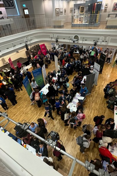 Ariel view of crowds of people viewing exhibits in large hall