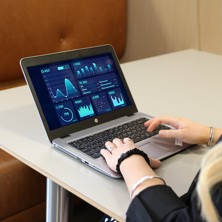 Person using a laptop with stats and graphs on the screen