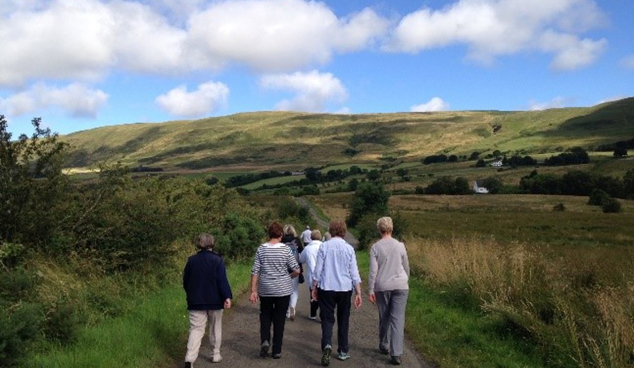 Group of people walking on a footpath towards the Campsies