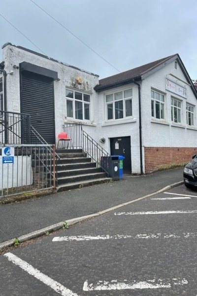 front of building with stairs to a metal shutter and white walls