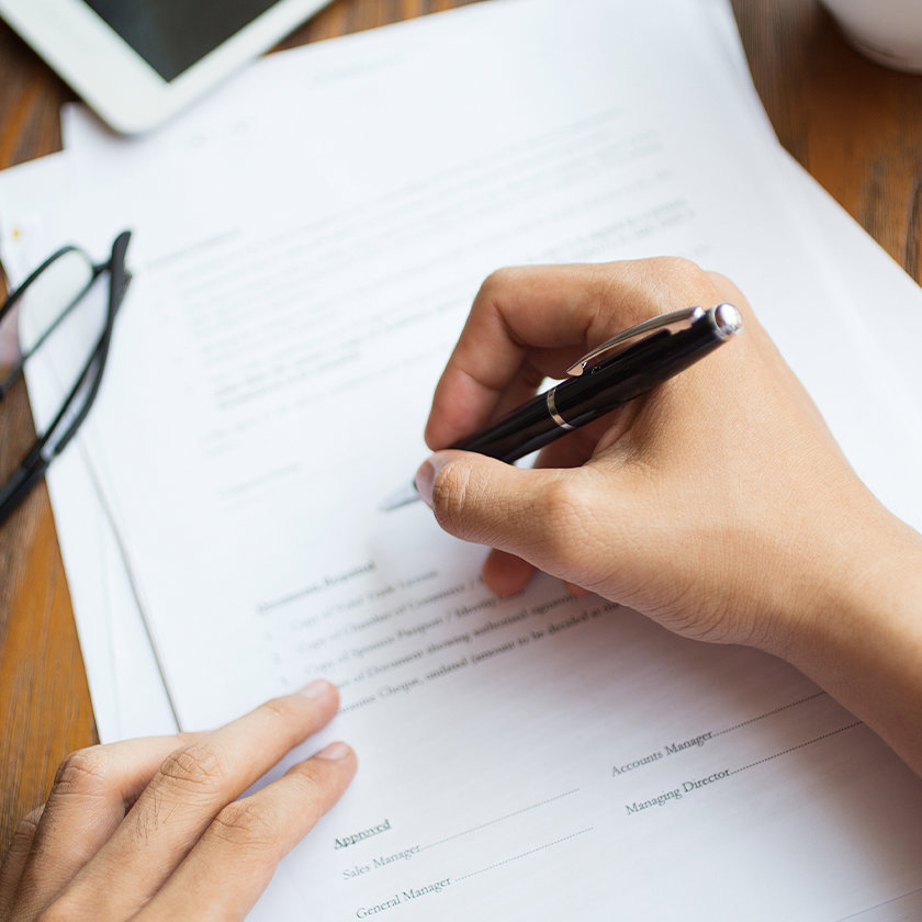 Person writing on a sheet of paper