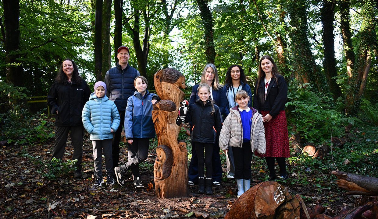 Cairnhill wooden a sculpture with school children and councillors round it