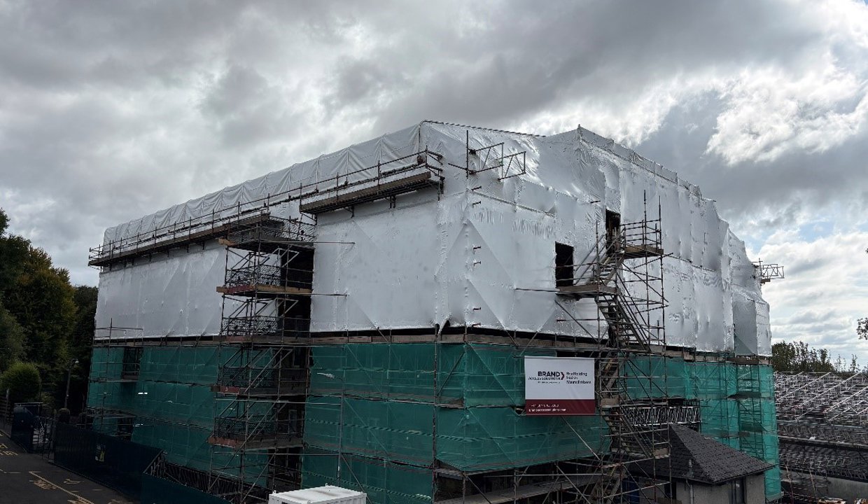 School swathed in protective sheeting over scaffolding