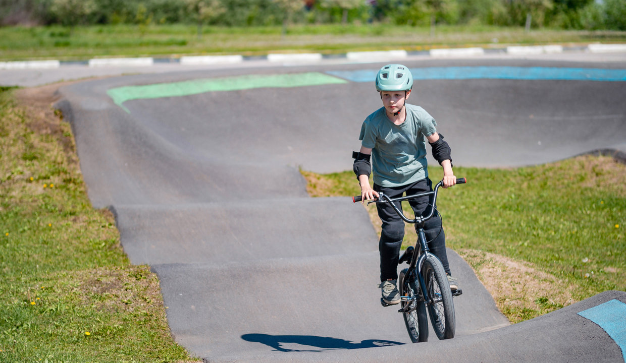 Boy riding a bike along the pump track
